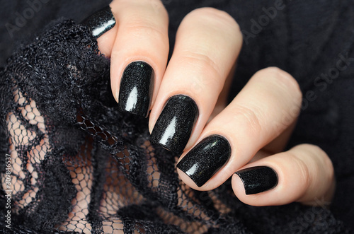 dark blue manicure on a background of black lace