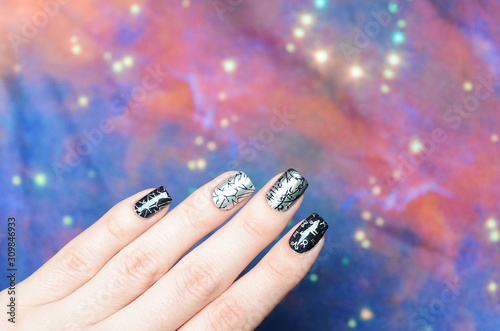 black and gray manicure with a constellation map pattern on a cosmic background