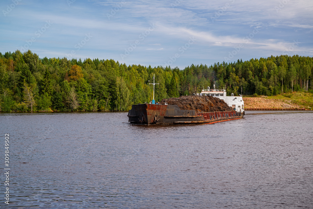 Barges with cargo swimming along the banks of the north-west river Barges with cargo swimming along the banks of the north-west river