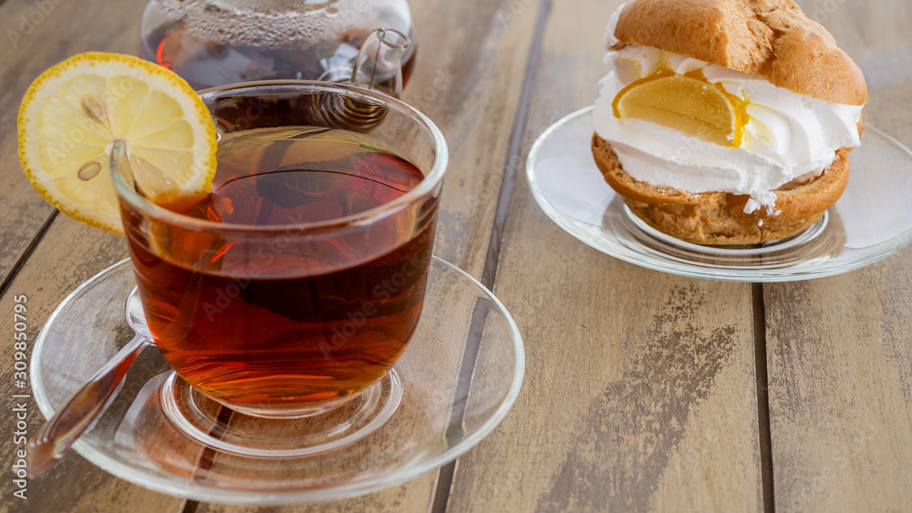 cake and cup of tea with mint on a wooden background