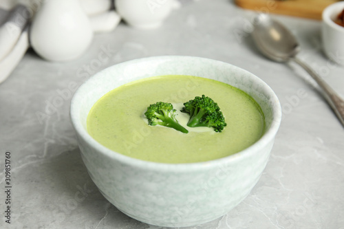 Delicious broccoli cream soup served on grey marble table
