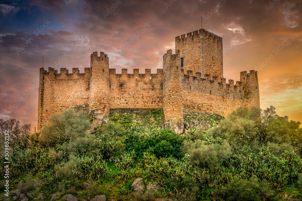 Almourol castle built by the templar knights on an island in the Tagus river near Tomar Portugal with battlements, donjon and dramatic colorful sky