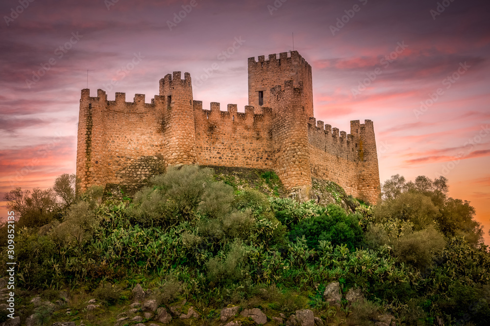 Almourol castle built by the templar knights on an island in the Tagus river near Tomar Portugal with battlements, donjon and dramatic colorful sky