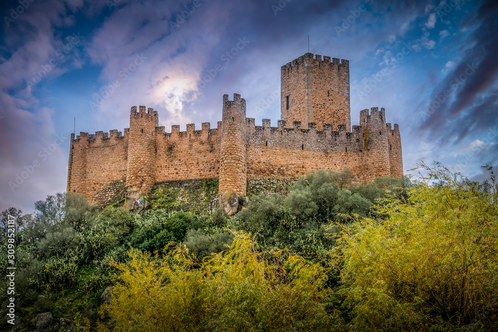 Almourol castle built by the templar knights on an island in the Tagus river near Tomar Portugal with battlements, donjon and dramatic colorful sky