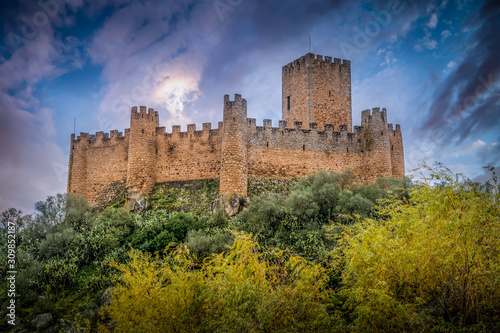 Almourol castle built by the templar knights on an island in the Tagus river near Tomar Portugal with battlements, donjon and dramatic colorful sky