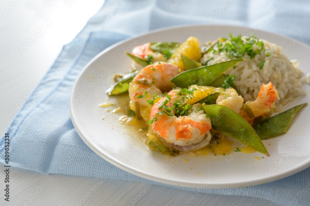 Seafood meal from fried tiger prawn shrimps with sugar peas, oranges and rice Seafood meal from fried tiger prawn shrimps with sugar peas, oranges and rice