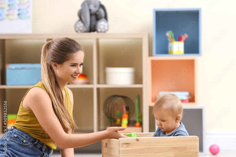 Teen nanny playing with cute little baby at home Teen nanny playing with cute little baby at home
