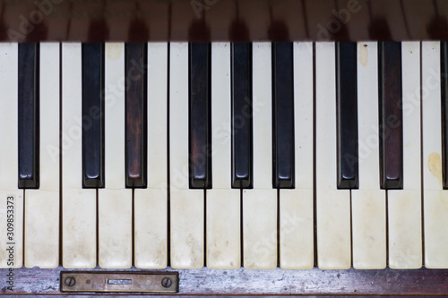Aged piano with dirty keys and reflections