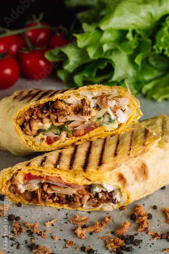 Shawarma sandwich gyro fresh roll of lavash pita bread chicken beef shawarma falafel RecipeTin Eatsfilled with grilled meat, mushrooms, cheese. Traditional Middle Eastern snack. On peper background
