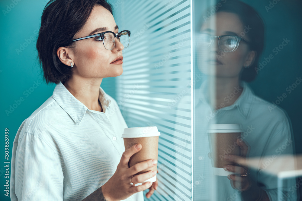 Young woman in glasses looking away in office Young woman in glasses looking away in office