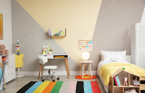 Stylish child room interior with comfortable bed and desk photo
