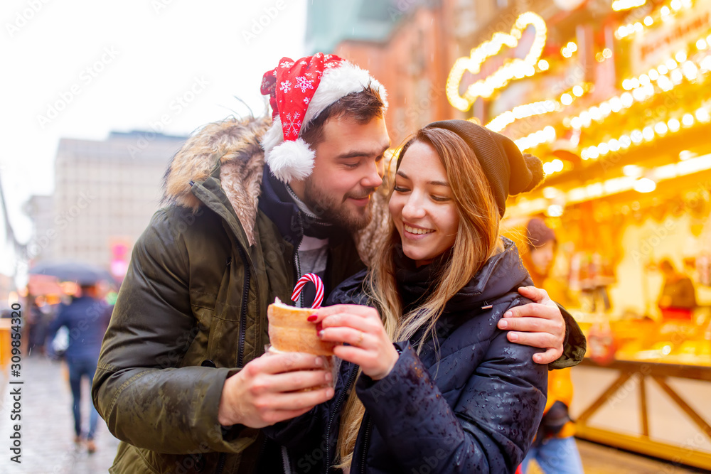 Young couple with bun in Christmas market