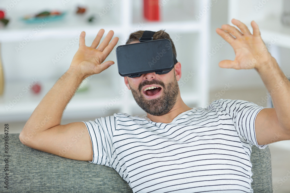 Naklejka premium happy smiling man with vr headset try to touck reality