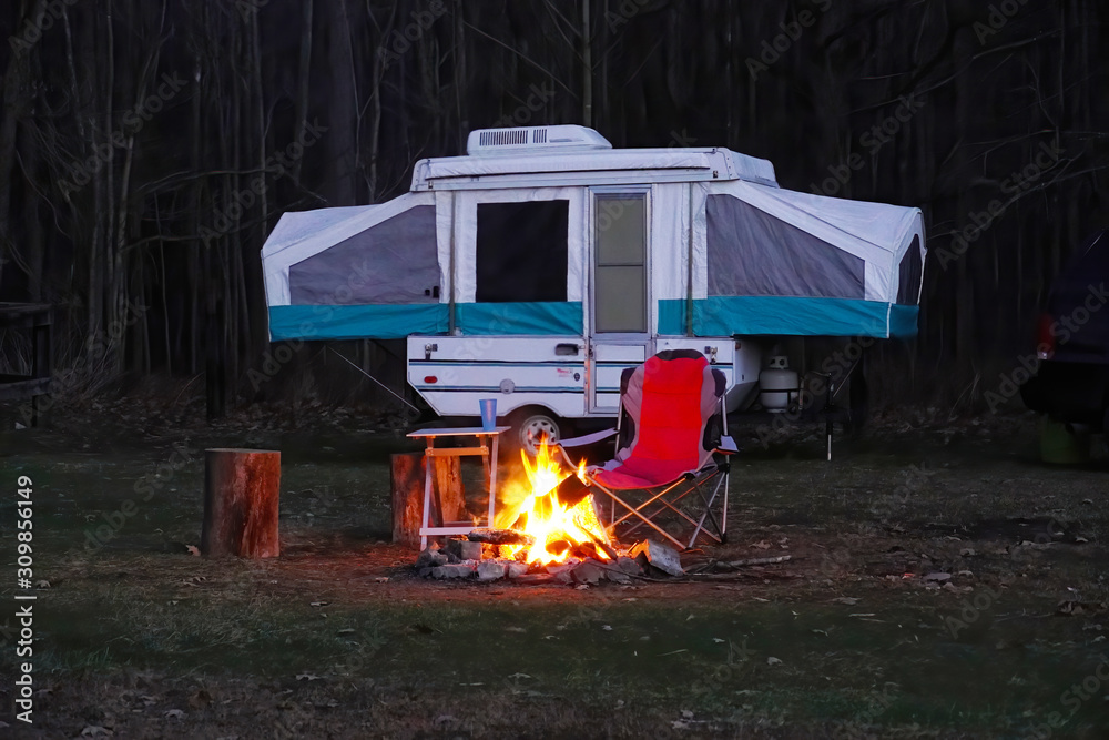 Pop Up Camper with camp fire in the woods,  Camping in the forest