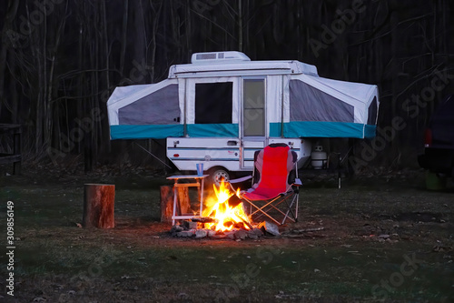 Pop Up Camper with camp fire in the woods,  Camping in the forest photo