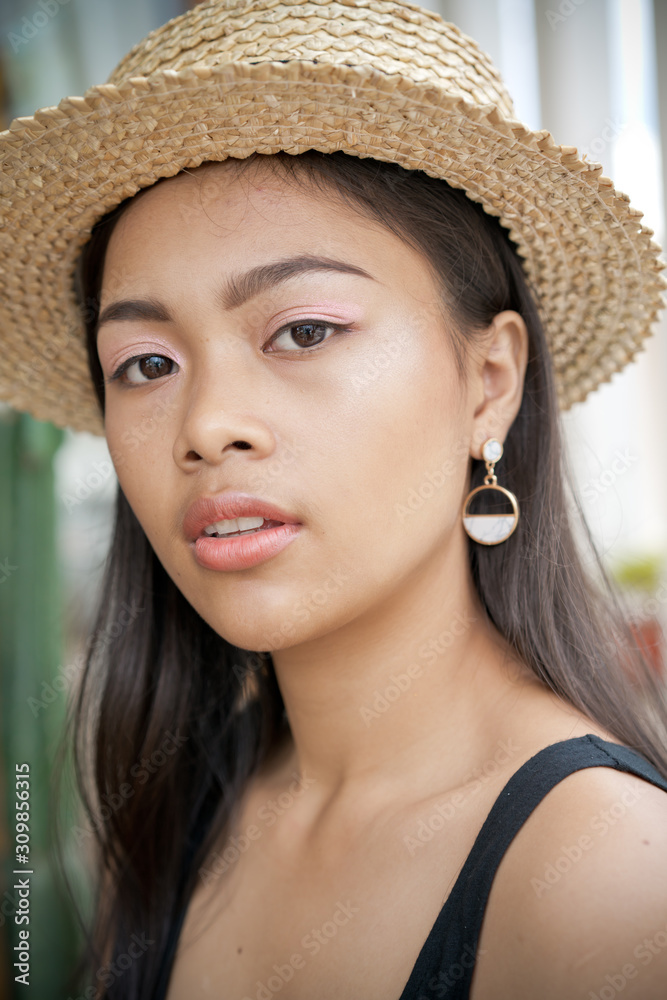 Asian girl portrait in straw hat. Beautiful Balinese women. Summer holiday time