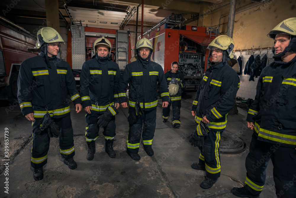Firemen preparing for emergency service. Firefighters putting on gloves. Firemen preparing for emergency service. Firefighters putting on gloves.