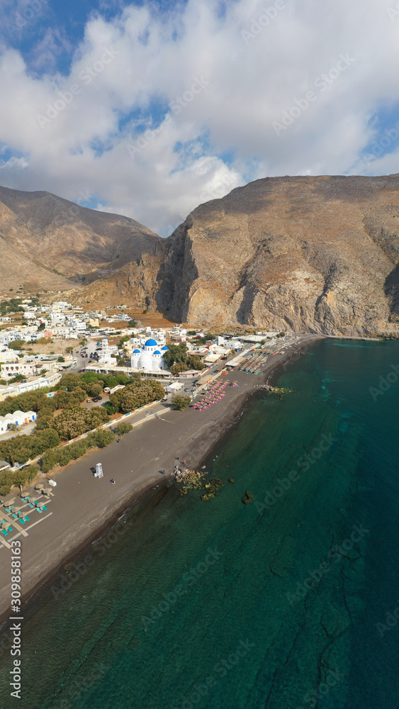 Aerial drone panoramic photo of famous black sand volcanic beach of Perissa in island of Santorini, Cyclades, Greece
