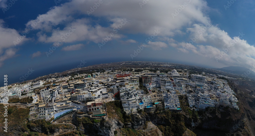 Aerial drone panoramic photo of main village of Santorini island called Fira built uphill with beautiful colours and architecture, Cyclades, Greece