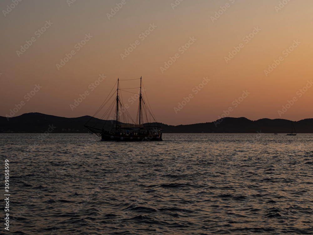 Silueta negra de un barco en las aguas de Zadar , Croacia, al atardecer, verano de 2019