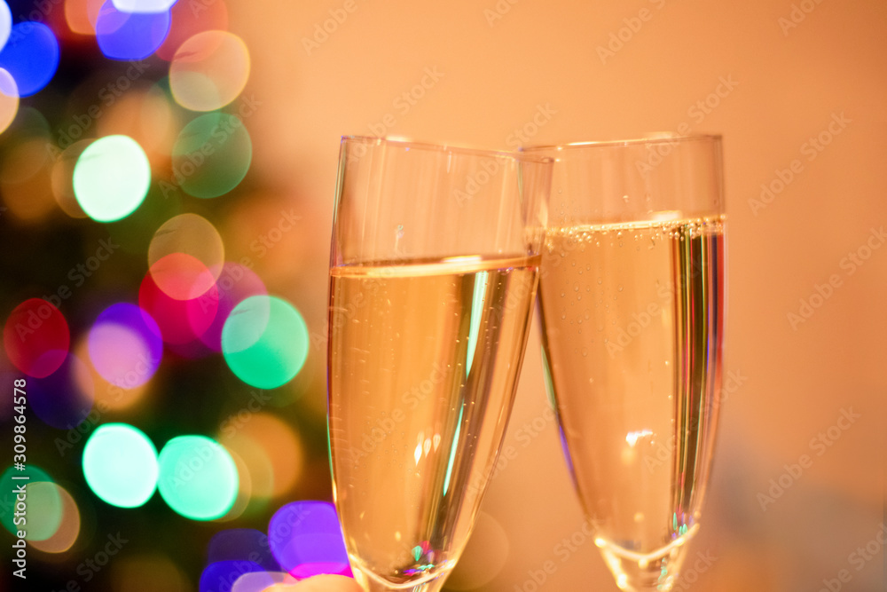 Blurred christmas tree and two glasses with sparkling wine champagne. New Year concept Blurred christmas tree and two glasses with sparkling wine champagne. New Year concept