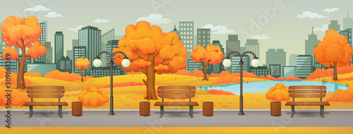 Autumn day park,street scene. Benches with trash cans and street lamps on a trail with orange and yellow trees and bushes. Meadow, lake, skyscrapers and gray sky with clouds in the background.
