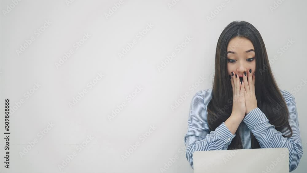 Amazed asian lady sitting on the floor with laptop, covering her mouth by a hands surprised with something. Amazed asian lady sitting on the floor with laptop, covering her mouth by a hands surprised with something.