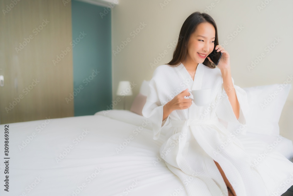 Portrait beautiful young asian women with coffee cup and mobile phone on bed Portrait beautiful young asian women with coffee cup and mobile phone on bed