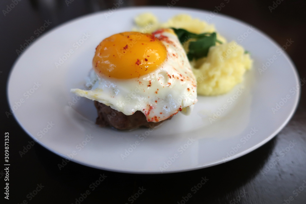 beef steak with egg and mashed potatoes on a white plate in a restaurant beef steak with egg and mashed potatoes on a white plate in a restaurant