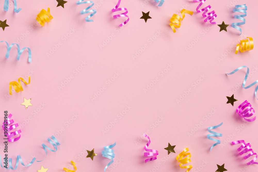 Colorful serpentine and golden stars, on pink  background. Flat lay, top view, copy space.