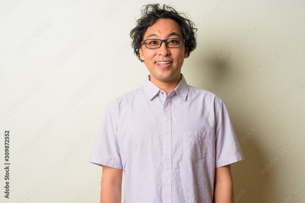 Portrait of happy Japanese man with curly hair smiling Portrait of happy Japanese man with curly hair smiling