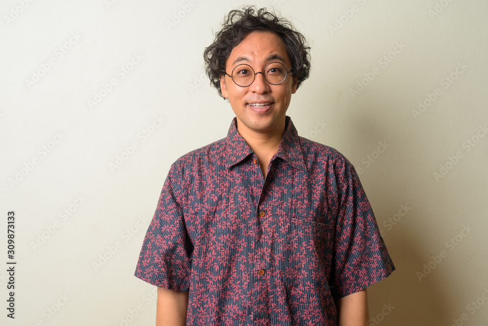 Portrait of happy Japanese man with curly hair smiling Portrait of happy Japanese man with curly hair smiling