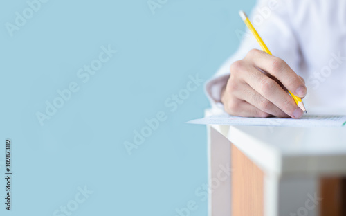high school,university student study.hands holding pencil writing paper answer sheet.sitting lecture chair taking final exam attending in examination classroom.concept scholarship for education abroad