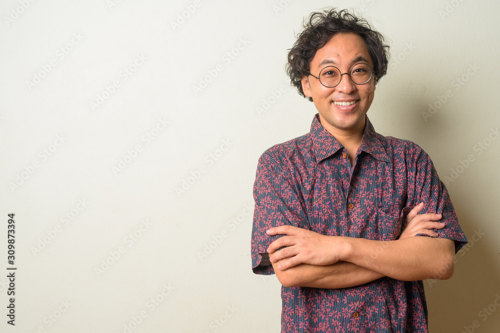 Portrait of happy Japanese man smiling with arms crossed Portrait of happy Japanese man smiling with arms crossed