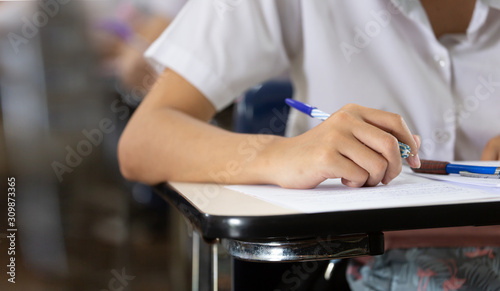 high school,university student study.hands holding pencil writing paper answer sheet.sitting lecture chair taking final exam attending in examination classroom.concept scholarship for education abroad © panitan