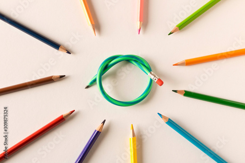 Colored pencils with one flexible pencil on white background. The concept of flexibility in decision-making.
