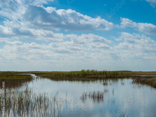 Far reaching everglades grass and water with dynamic sky in Everglades National Park, Florida, USA .