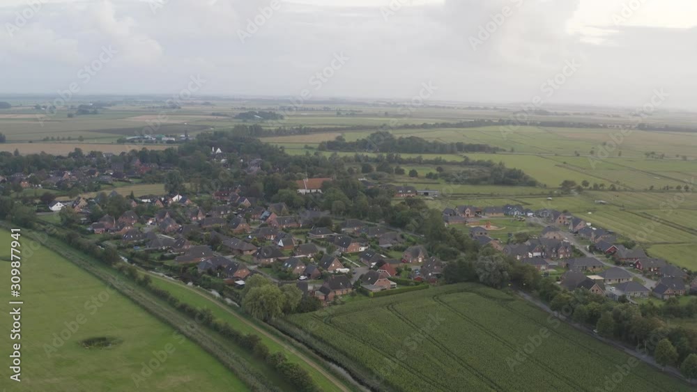 Cinematic drone / aerial overflight shot of a little village with a historic church with grass / meadow and flields around at the evening, 30p Cinematic drone / aerial overflight shot of a little village with a historic church with grass / meadow and flields around at the evening, 30p