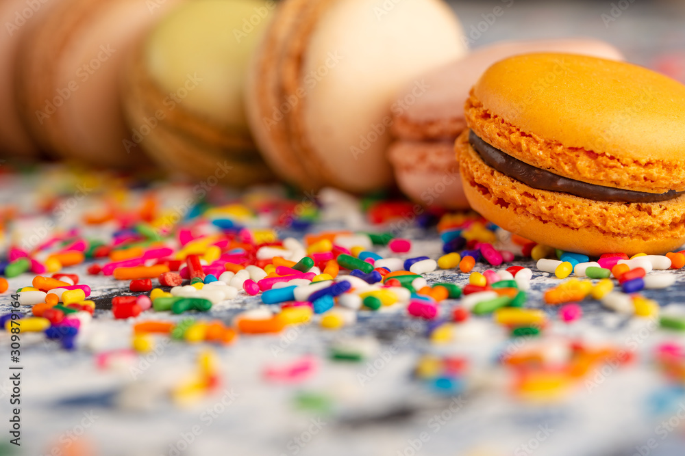 Macro, close-up of colored french macaroons, sweets with colored caramel sweets.