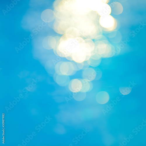 Bokeh light effects over a rippled, blue water background