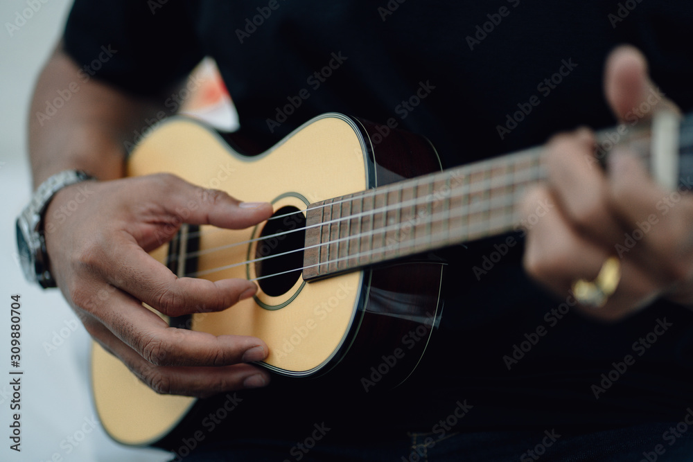 Close up man's hands playing the ukulele, concept ralax or artist.