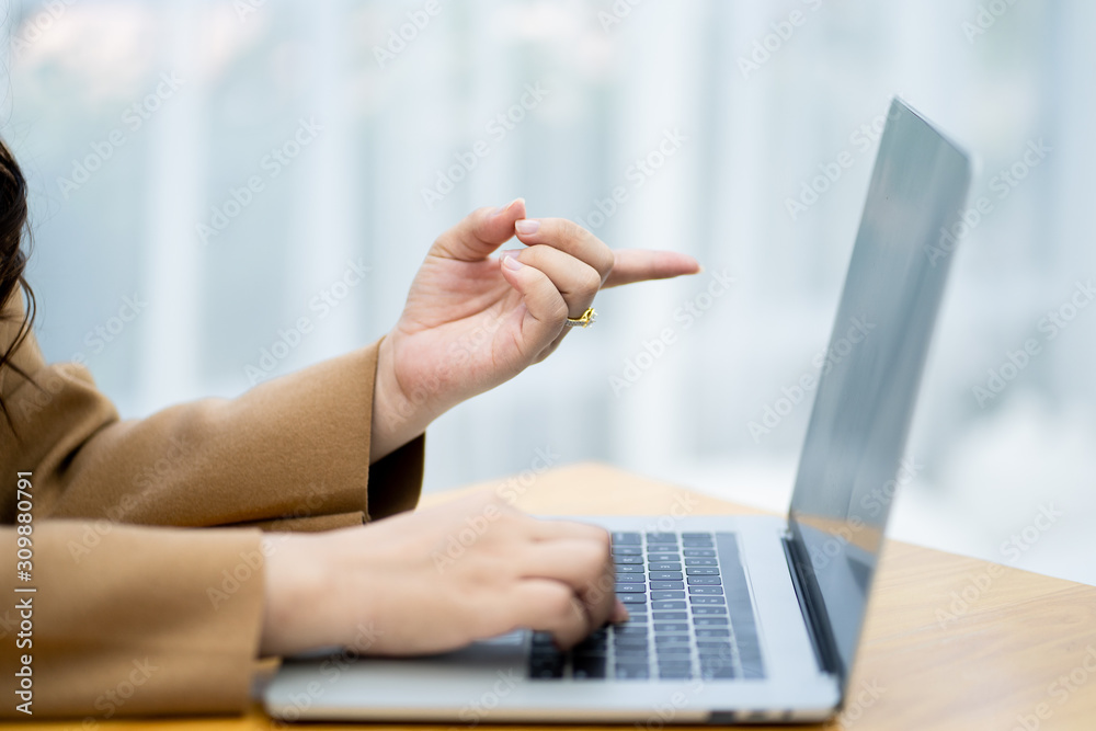 Close up hands of female pointing at laptop.