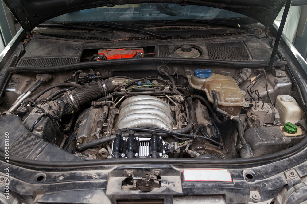 Hood space used car in a workshop for the repair and maintenance of vehicles during engine overhaul. Auto service industry. Hood space used car in a workshop for the repair and maintenance of vehicles during engine overhaul. Auto service industry.