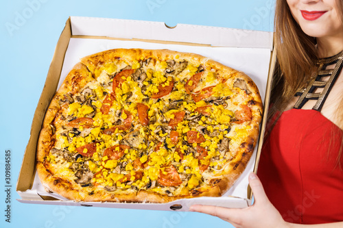 Woman holding big pizza in box