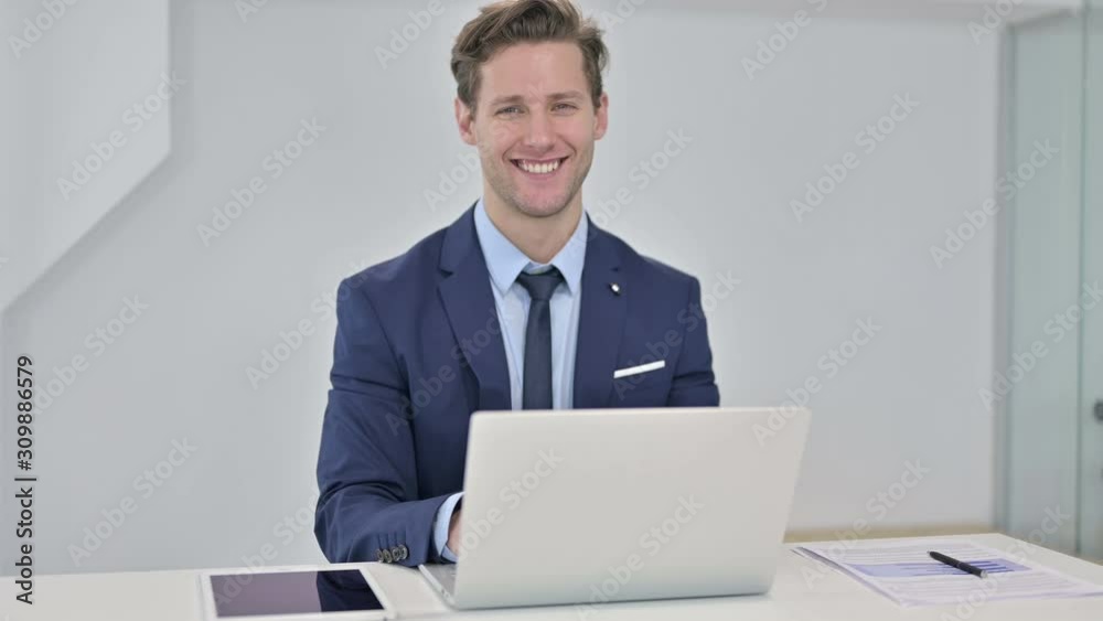 Attractive Young Businessman Looking at the Camera and Smiling Attractive Young Businessman Looking at the Camera and Smiling