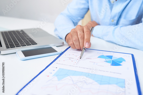 Financial manager pointing at chart with financial data in annual report