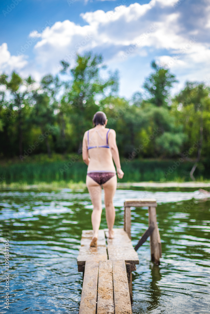 A beautiful woman jumping into the water from a pier. A beautiful woman jumping into the water from a pier.