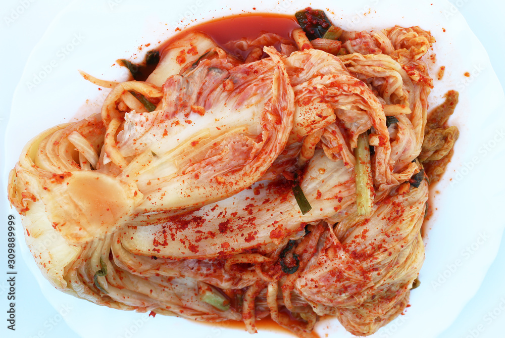 Traditional korean kimchi cabbage on a white plate close-up top view. Traditional korean kimchi cabbage on a white plate close-up top view.
