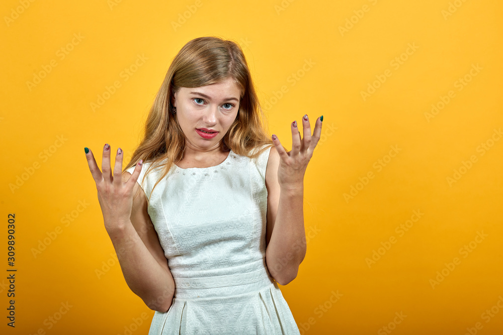Attractive caucasian young lady keeping fingers up, looking disappointed, angry over isolated orange background wearing white shirt. Lifestyle concept