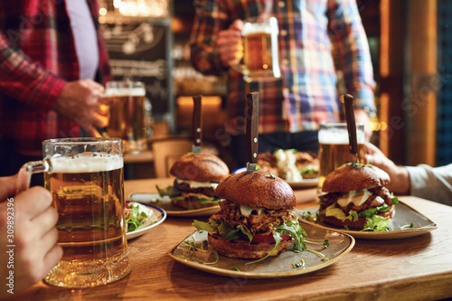 Burger with beer on the table in a bar pub.